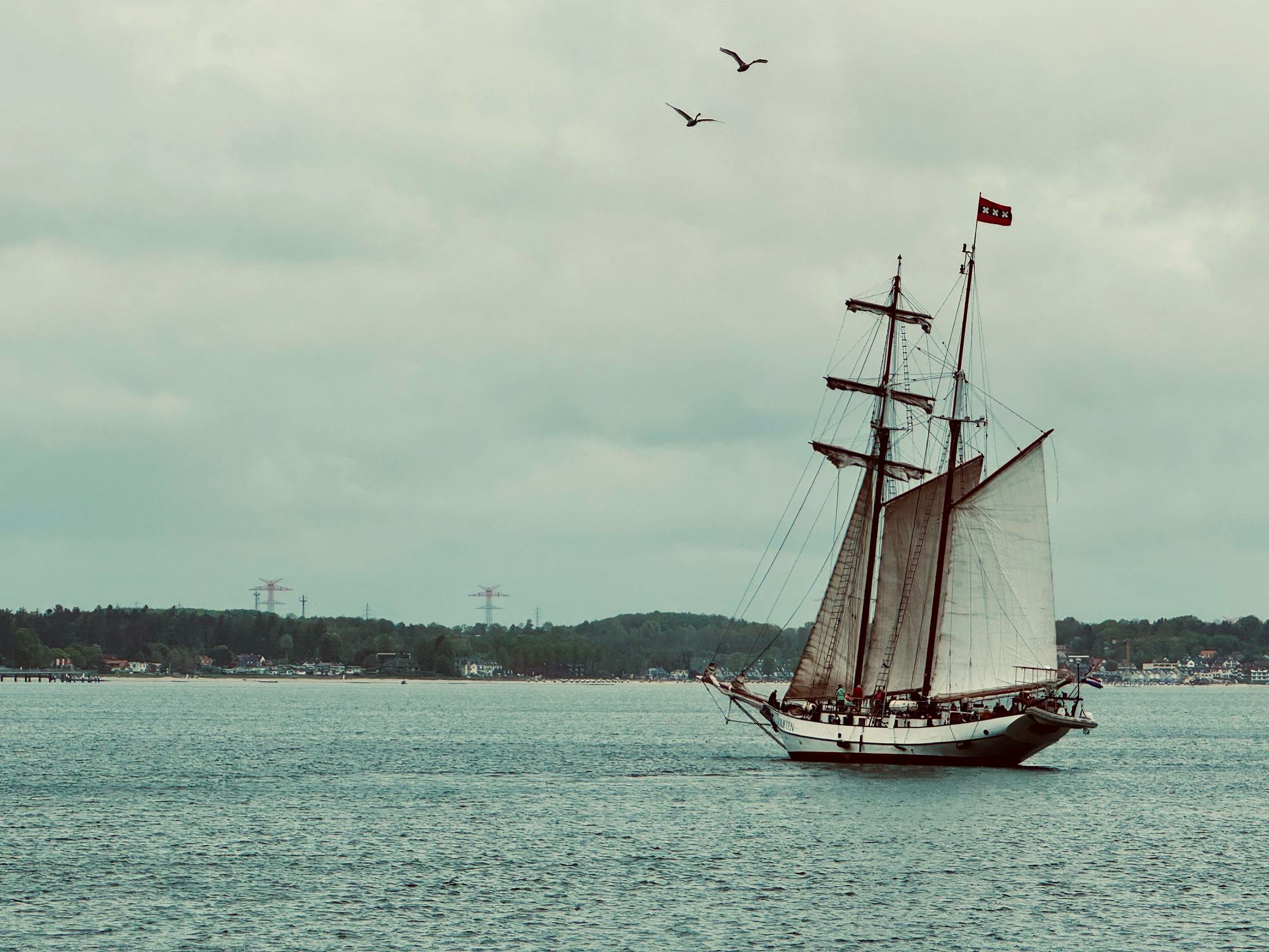 A tall ship sailing on the Baltic Sea under a cloudy sky